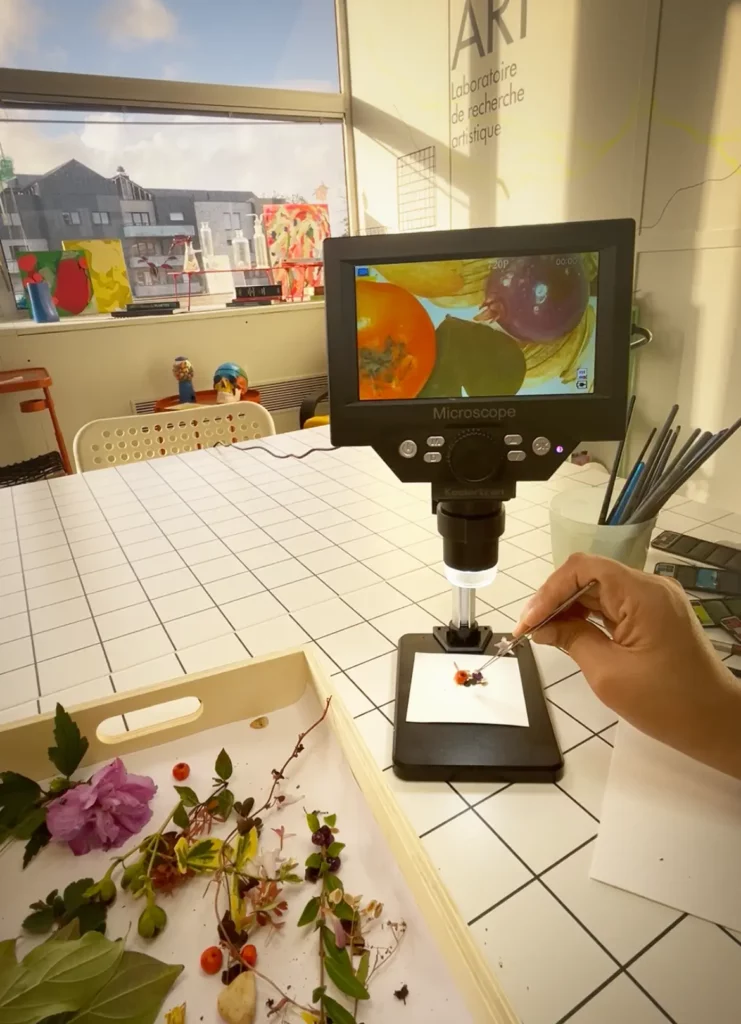 Adulte préparant des éléments végétaux dans le microscope pour créer une scène artistique