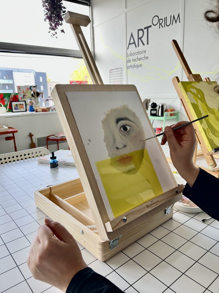 Adulte en train de peindre les traits d’un visage sur une toile