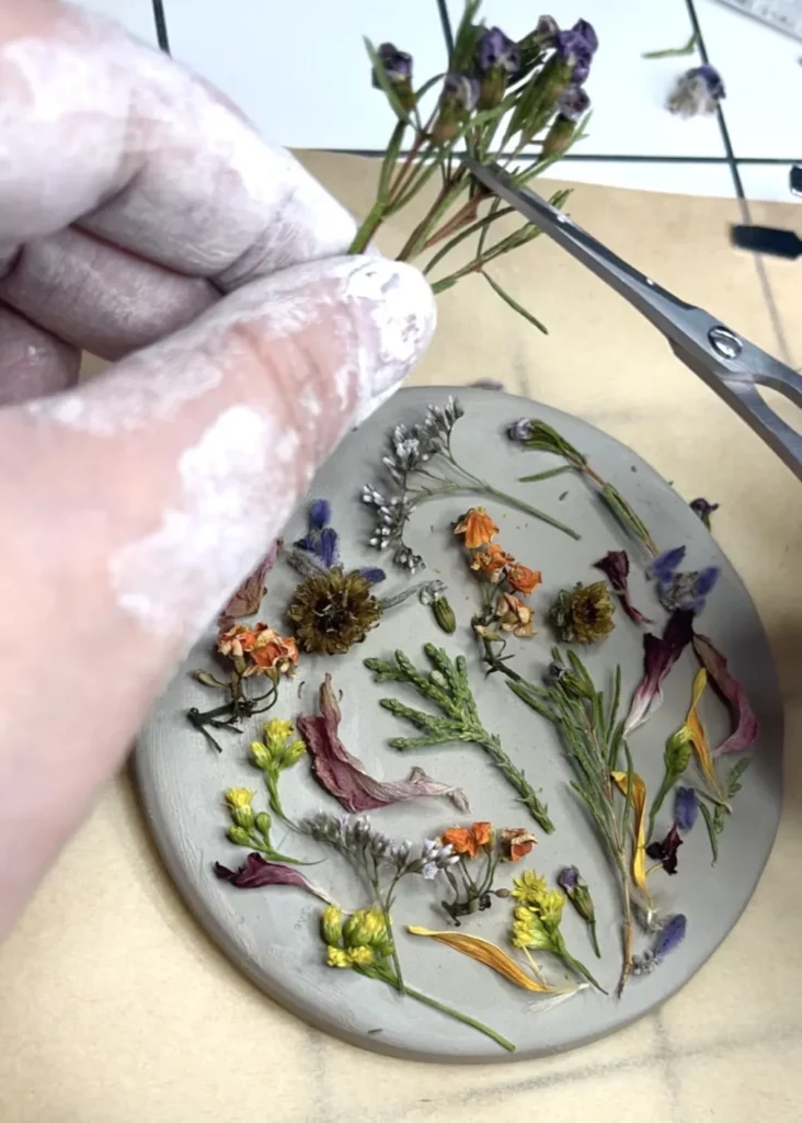 Modelage argile medaillon fleurs séchées